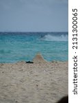 Small photo of Riviera Maya, Mexico - February 17, 2022 : paradisiacal beach of the Mexican Caribbean, with the Chichen Itza pyramid of sand made by a child, next to sandals, symbolic more than adequate to insinuate
