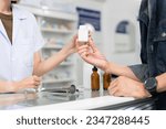 Small photo of Close up hands of selling female pharmacist and male customer buying medicine in the pharmacy drugstore, hand over capsule pills of medicine from hand to another hand charge.