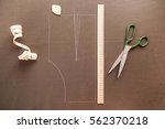 Still life photo of a suit pattern template with tape measure, chalk and scissors. Sewing and tailoring tools and accesories.   