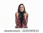 Happy satisfied woman clenching her fists feeling euphoric and celebrating her success, medium shot isolated studio shot luck concept. High quality photo