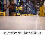 Small photo of Warehouse workers keeping track of goods distribution. Supervisors doing inspection in large storage stockroom.