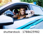 Small photo of Woman with driving license. Driving school. Young beautiful woman successfully passed driving school test. Female smiling and holding driver's license.