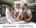 Small photo of Graphic engineers or workers checking imprint quality in modern print shop.
