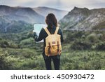 Hipster young girl with  backpack enjoying sunset on peak of mountain, looking map. Tourist traveler on background valley landscape  view mockup, sunlight in trip in  basque country, mock up for text.