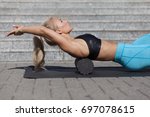 woman doing fascia exercise with foam roller on back