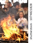 Small photo of MERON, ISRAEL - MAY 14, 2017: Traditional bonfire burns in honor of Rabbi Shimon bar Yochai on Jewish holiday of Lag Baomer, with a young boy in backround in Meron, Israel