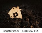 Small photo of Wooden house falls into ground. under the ground home mortgage, house for sale, real estate crisis concept, copy space. owe, indebted. Mortgage crisis. defaulter loses real estate. loss mortgaged home