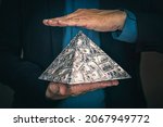 Small photo of a pyramid scheme in the hands of a fraudster. The concept of exchange in financial markets is the collapse of the financial system of capitalism.