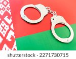 Small photo of Belarus flag and police handcuffs. The concept of crime and offenses in the country. the concept of crime in the state or government of the country.