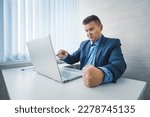 angry businessman in a jacket slams his fist on the table in anger. the Internet or computer does not work bad news, bankruptcy.