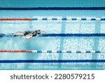 Small photo of Top view shot of young man swimming laps in swimming pool. Male swimmer swimming the front crawl in a pool. swimming crawl.