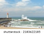 Small photo of Waves crashing against the harbour wall in Porto, Portugal, Europe. Lighthouse in view, space for text, showing strength, natural power and ferocity of the sea 17 MAY 2022
