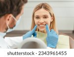 Small photo of Portrait of attractive young woman with toothy smile sitting in dental chair, dentist checking teeth. Female patient with toothy smile in modern dentistry. Dental care concept