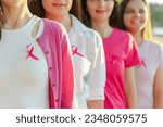 Small photo of Smiling confident beautiful women wearing t shirts with breast cancer pink ribbon standing on the street. Health care, support, prevention. Breast cancer awareness month concept