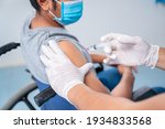 Small photo of Doctor making a vaccination in the shoulder of patient Disabled person, Flu Vaccination Injection on Arm, coronavirus, covid-19 vaccine disease preparing for human clinical trials vaccination shot.