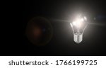Small photo of Light bulb with electric power abstract creative idea think innovation technology inspiration with flickering light lens flare on isolated black backgrounds