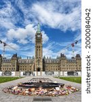 Small photo of Ottawa, Canada - June 30, 2021: The many shoes and toys left on Parliament Hill in memory of the children whose remains were found near former Residential Schools. The Canadian flag flies at half-mast