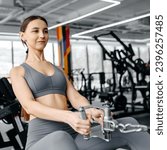 Small photo of young athletic caucasian woman trains in fitness gym, thrust in block simulator, brunette girl in grey top and leggings, healthy lifestyle concept, square photo
