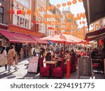 Small photo of London, UK - April 20, 2022: People eating alfresco at busy Chinese restaurant in Gerrard Street in the Chinatown district