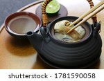 Small photo of dobin mushi (Japanese cuisine) : steamed matsutake mushroom and pike conger with Japanese broth in an earthenware teapot and served.