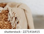 Small photo of Beautiful beige linen fabric rests inside a rustic woven basket. The natural, soft of the linen fabric and the rustic woven texture of the basket make for a perfect complement to cozy interior design.
