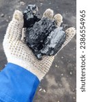 Small photo of A Handful of Potential. A person holding a piece of coal, symbolizing the tangible power and energy within this natural resource.