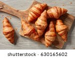 freshly baked croissants on wooden cutting board, top view