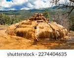 Small photo of Pinkerton Hot Spring and Rocky Mountain landscape in Colorado with blue sky and clouds.