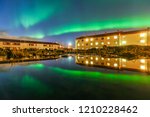 Northern Lights (Aurora) With Buildings Reflection In The Water Near Keflavik Airport , Iceland
