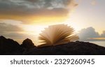 Small photo of Scriptures on pages of open book at sunset. Rocky lifeless planet. In the begining there was the word, and the word was with God.