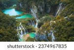 Waterfalls in the autumn forest flowing into lakes. Tourists visit famous Plitvice park in Croatia. Mountain streams with clear water.