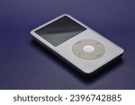 Small photo of Brooklyn, NY - Dec 4 2023: Apple Ipod classic portable mp3 player on a blue background.