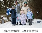 Small photo of Finnish family with Finland flags on a nice winter day. Nordic Scandinavian people.