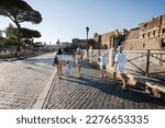Small photo of Family tourists walking in street Via dei Fori Imperiali in Rome, Italy.