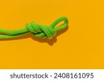 Small photo of rope with a secure knot. concept of reliability and safety. climbing rope with a knot lies on a colored background. rope with a knot.