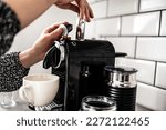 Girl hand put capsule to coffee machine closeup. Woman preparing italian caffeine beverage using professional espresso maker