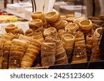Trdelník - Kürtőskalács - Chimney cake - Spit cake. Window display of fresh products. Popular cake made with layers of dough deposited onto rotating spit.