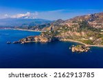 Taormina is a city on the island of Sicily, Italy. Mount Etna over Taormina cityscape, Messina, Sicily. View of Taormina located in Metropolitan City of Messina, on east coast of Sicily island, Italy.