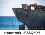 Small photo of Detail of the rusty stern of a ship stranded on the coast of Arrecife in Lanzarote, called Telamon. Rusty ship. Stranded ship. Broken ship. Lanzarote, Canary Islands, Spain