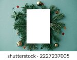 Christmas card flat lay. Modern greeting card mock up with stylish christmas decorations, fir branches, ornaments on green background. Empty postcard template with space for text. Merry Christmas!