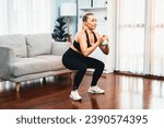 Small photo of Athletic and sporty senior woman engaging in leg day training session with squat and bodyweight kettle ball at home exercise as concept of healthy fit body lifestyle after retirement. Clout