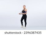 Small photo of Full body length shot athletic and sporty senior woman with fitness resistance band on isolated background. Healthy active physique and body care lifestyle after retirement. Clout