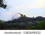 Small photo of Kaliwungu, Indonesia - 28 April 2019 : large and high garbage disposal locations, there are excavators that dredge up garbage and there are people who are looking for used goods