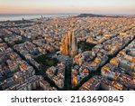 Aerial view of Barcelona Eixample residential district and Sagrada Familia Basilica at sunrise. Catalonia, Spain. Cityscape with typical urban octagon blocks