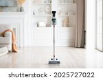 Close-up of wireless modern vacuum cleaner in light interior. House cleaning.