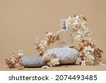 Small photo of Round Perfume bottle mockup on beige background. Pebble podium and dry hydrangea flowers. Natural earthy colors, copy space