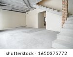 Construction. Unfinished building. Rough finish of the room. A large empty room with plastered walls in a house under construction. Concrete walls. Interior renovation.