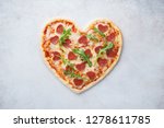 Heart shaped pizza with pepperoni. Valentines day romantic menu concept for restaurant or delivery.