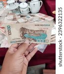 Small photo of Yogyakarta, December 3, 2023 : A piece of history in my hands – a 1998 print 10,000 Rupiah bill, a tangible connection to Indonesia's economic narrative.