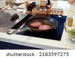 Cooking juicy tasty burger organic meat on hot pan in the kitchen at home. Cutlets fried in a frying pan. Food concept